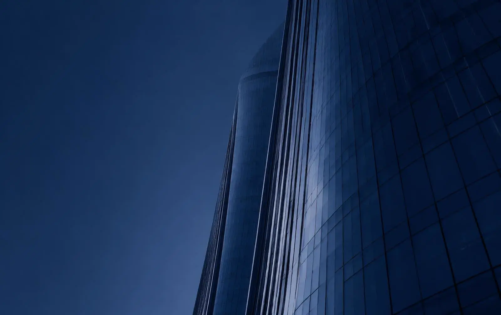 Glass facade of a Dubai office tower at dusk